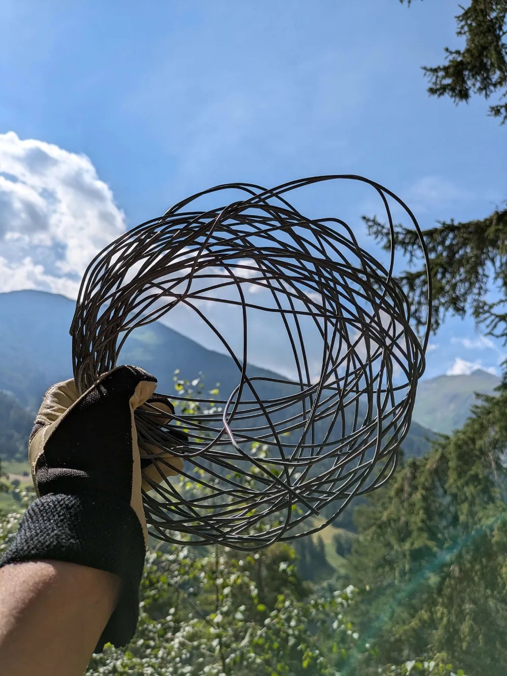 Person holding a wire that has been removed from nature as part of a clean-up event.